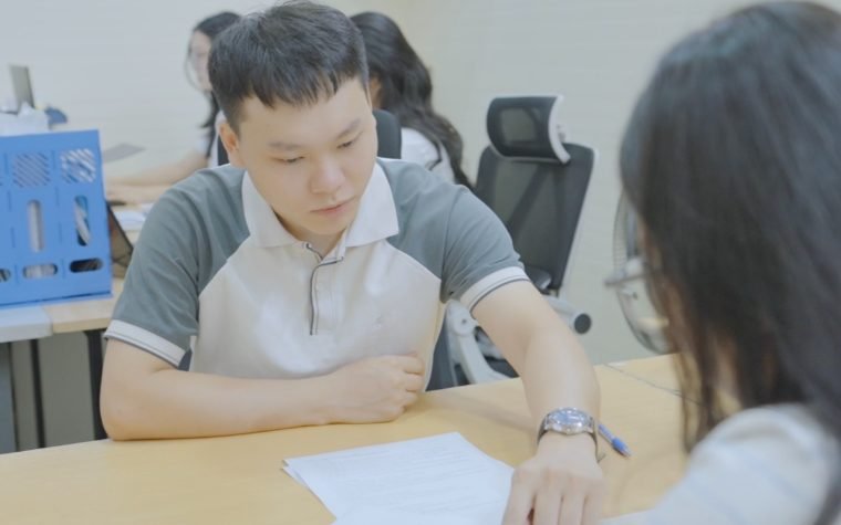 Tư vấn viên Bảo Châu giải thích bảng học phí cho học viên tại văn phòng